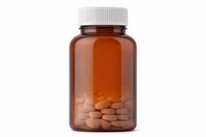 En bärnstensfärgad medicinflaska fylld med ZMA-tabletter mot en vit bakgrund.