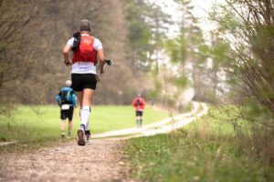 Traillöpare springer på en smal naturstig genom skogen